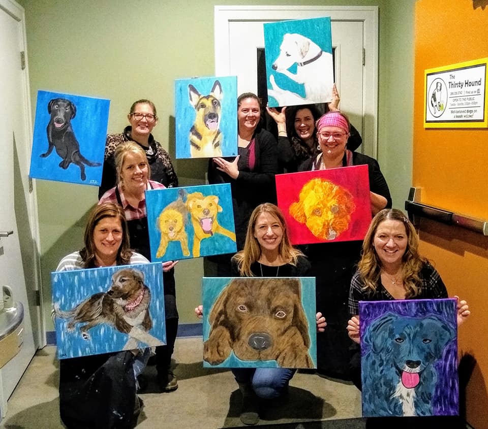 Group of women painting their dogs on canvas